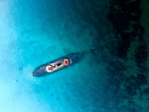 Free Drone shot of a sunken ship in Melbourne's vibrant blue waters. Stock Photo