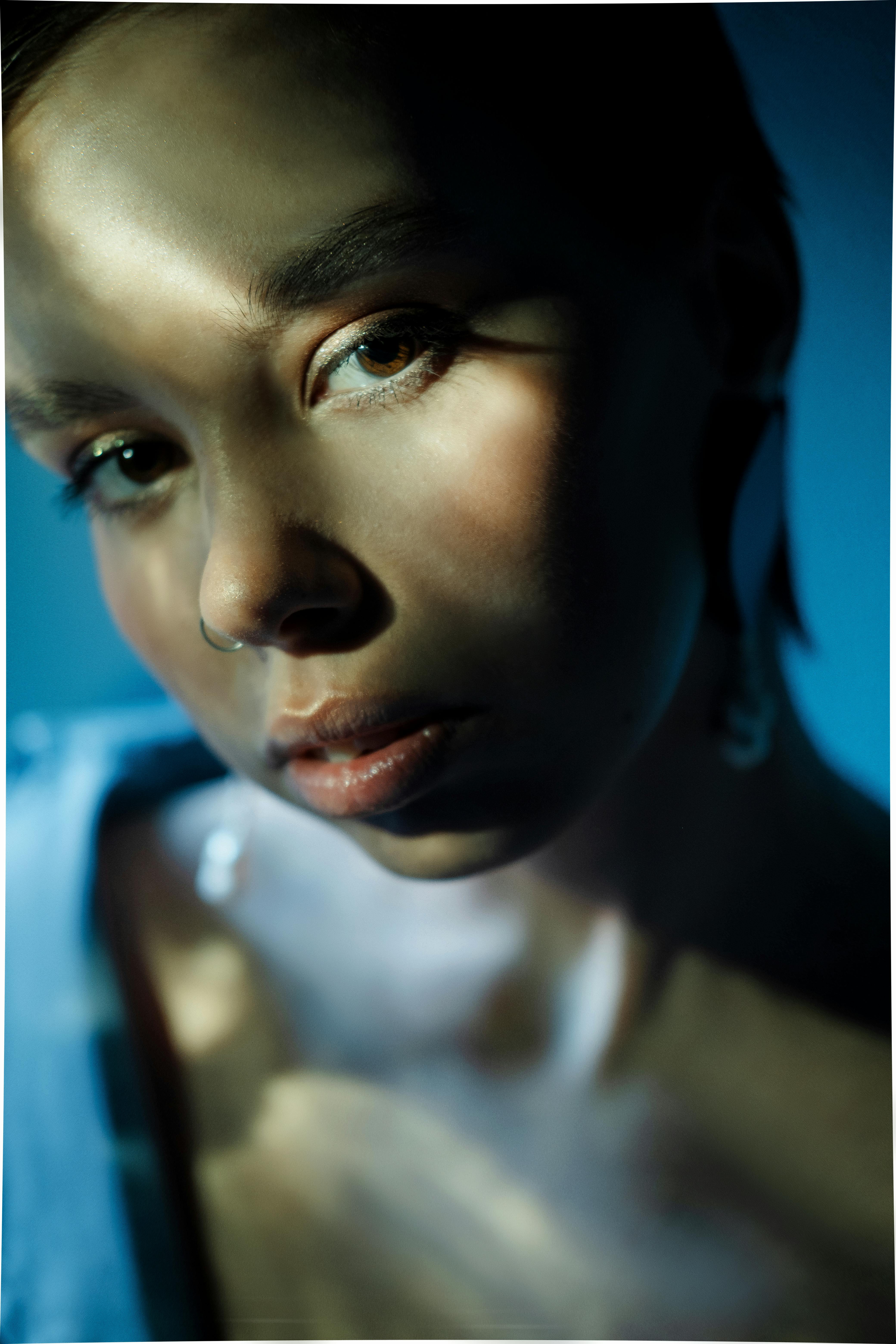 Close-up portrait of a woman with textured lighting creating dramatic shadows.