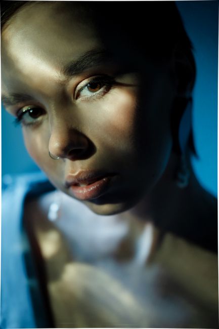 Close-up portrait of a woman with textured lighting creating dramatic shadows.