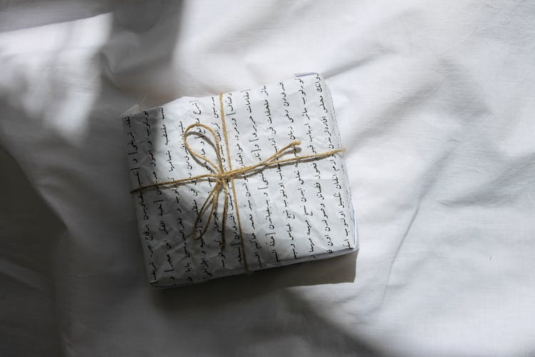 Gift Box With Brown Ribbon On White Textile