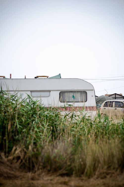 Free A stationary campervan amidst tall grass, representing a peaceful rural lifestyle. Stock Photo