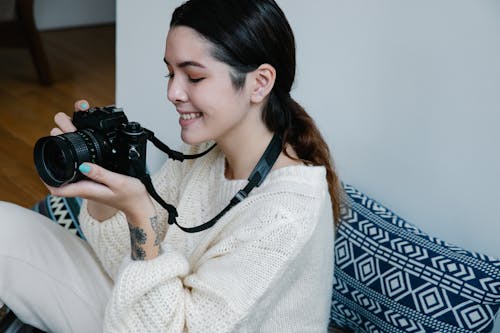 Woman in White Knitwear Holding Black Camera