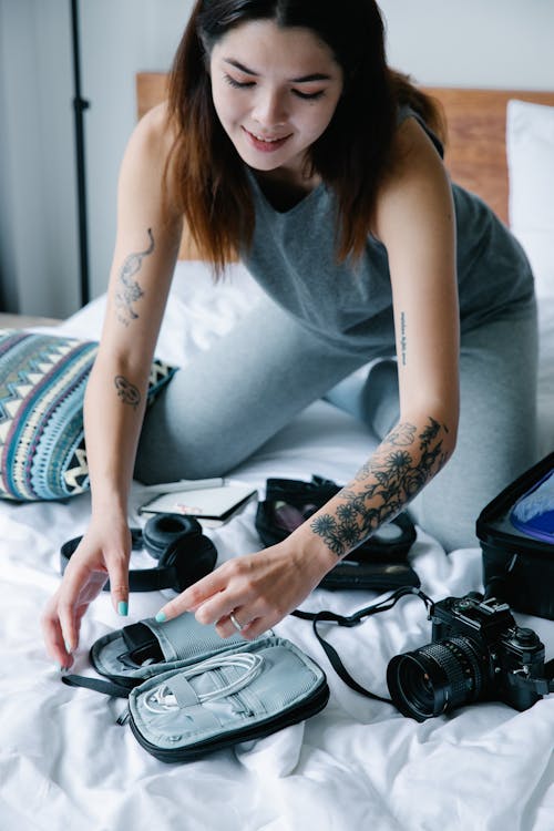 Woman in Gray Tank Top Looking at Gray Bag