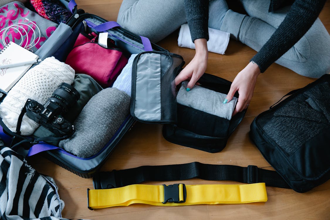 Free Unrecognizable Person Packing Clothes Stock Photo