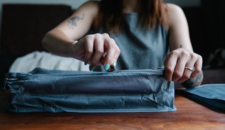 Woman Zipping A Bag