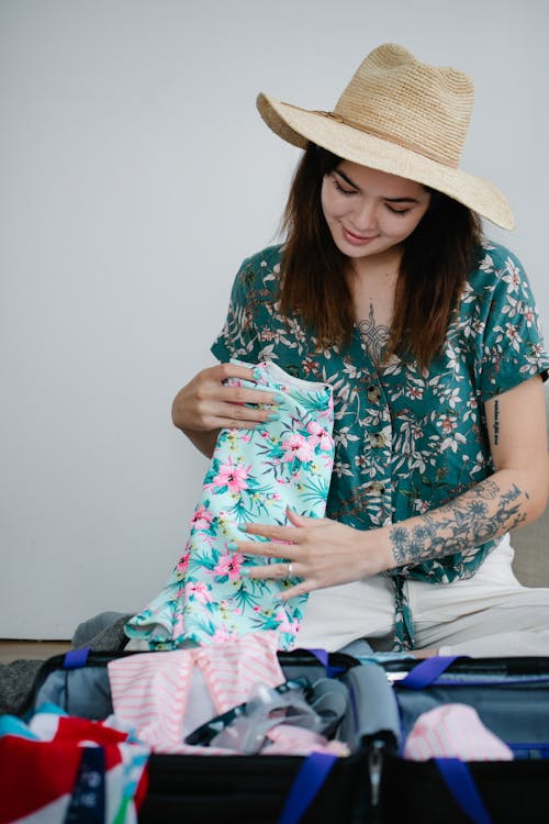Free Woman in Floral Shirt Folding Clothes Stock Photo