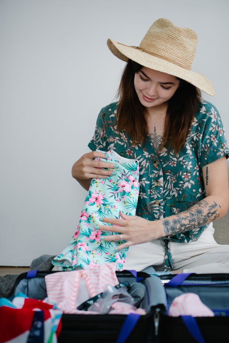 Woman In Floral Shirt Folding Clothes