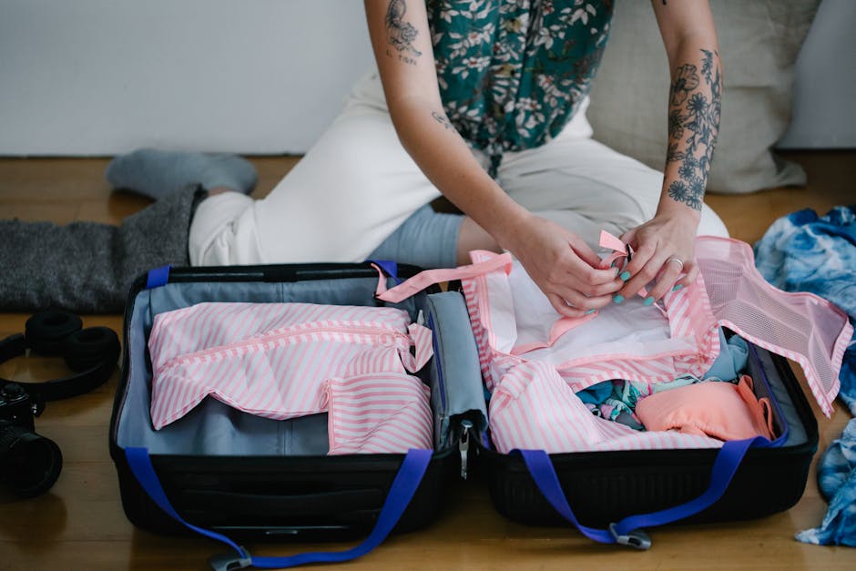 what to pack for a mayan adventure tour - A woman packing her travel suitcase on the floor indoors, preparing for a trip.