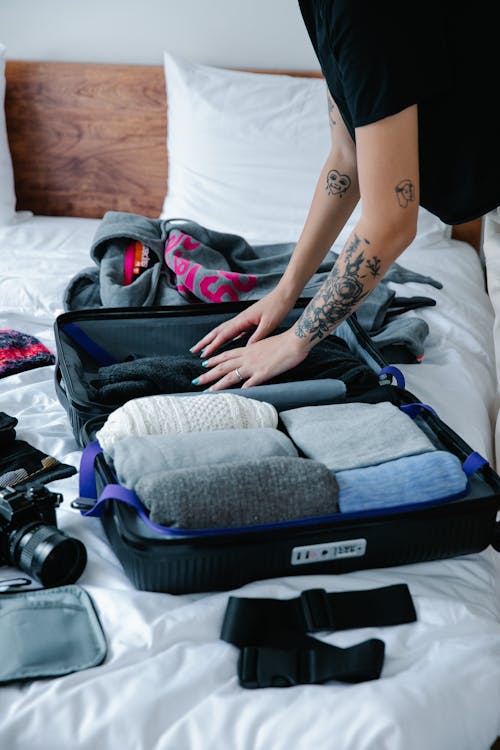 Free A Tattooed Person Fixing Her Luggage Stock Photo