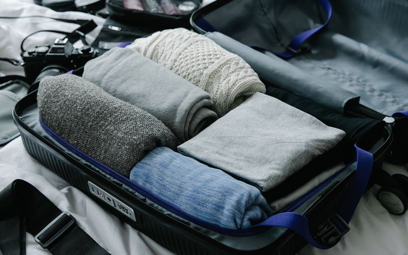 Open suitcase neatly packed with folded clothes