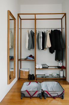 A minimal wardrobe with an open suitcase ready for packing, perfect for travel preparation visuals.