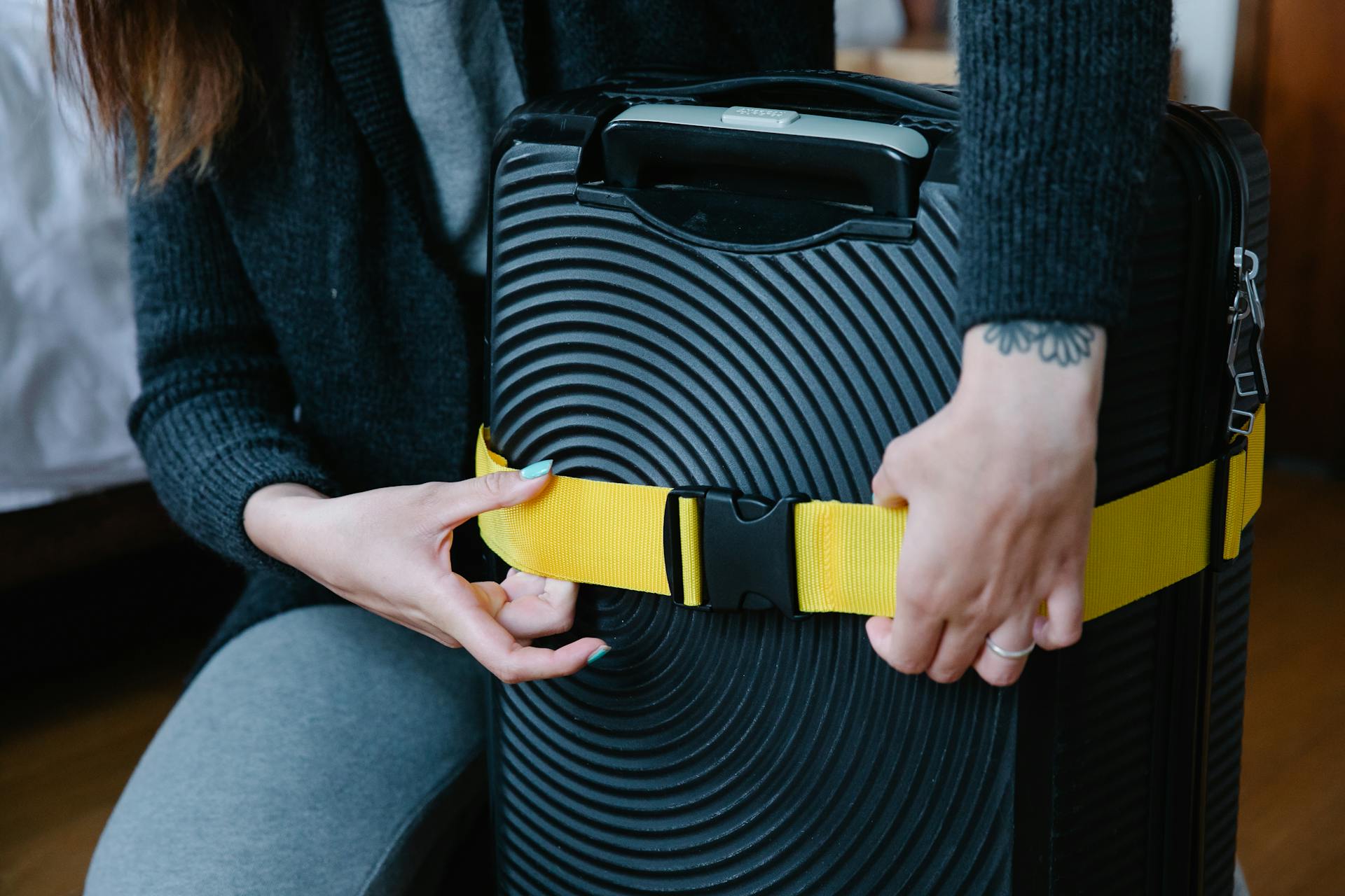 A Person Checking the Strap on Luggage