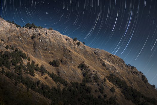 Stunning star trails over a rocky mountain landscape in Uttarakhand, India.