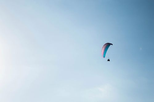 Free A person paragliding high above in the clear blue sky, embracing freedom and adventure. Stock Photo