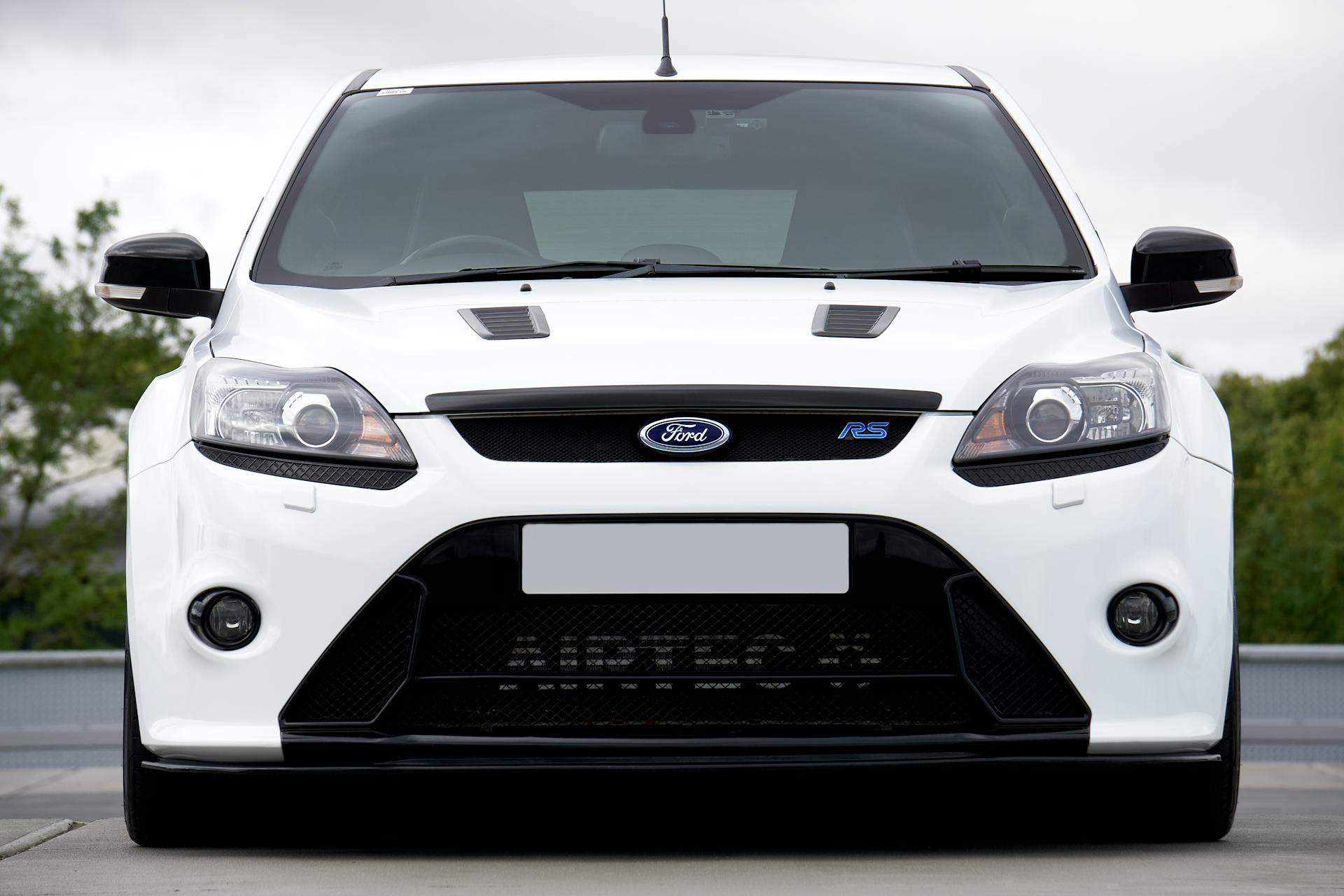 Close-up front view of a white Ford Focus RS car outdoors.