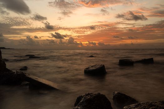 Tranquil sunset view over rocky coastal shore at Playa del Carmen, Mexico.