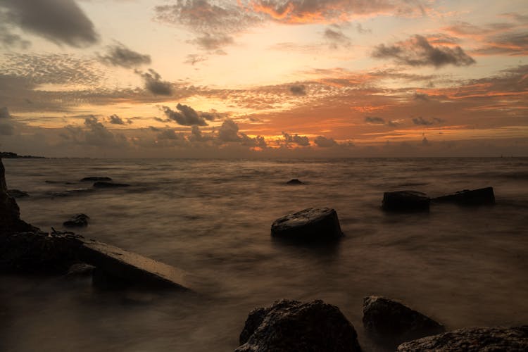 Sea Shore With Rocks At Sunset