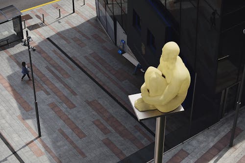Estatua De Hombre Sentado Colocada En Un Poste De Metal Gris