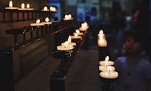 教堂内部宁静，点燃在金属支架上的蜡烛唤起了沉思的心情