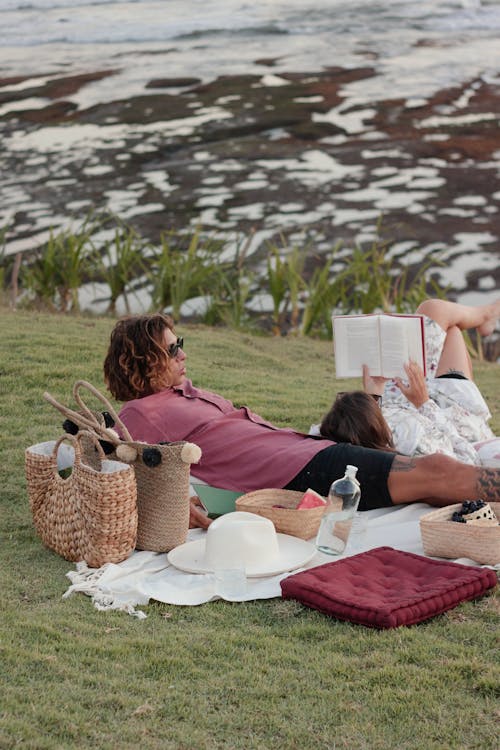 Free A Couple Sitting on Green Grass Field Stock Photo