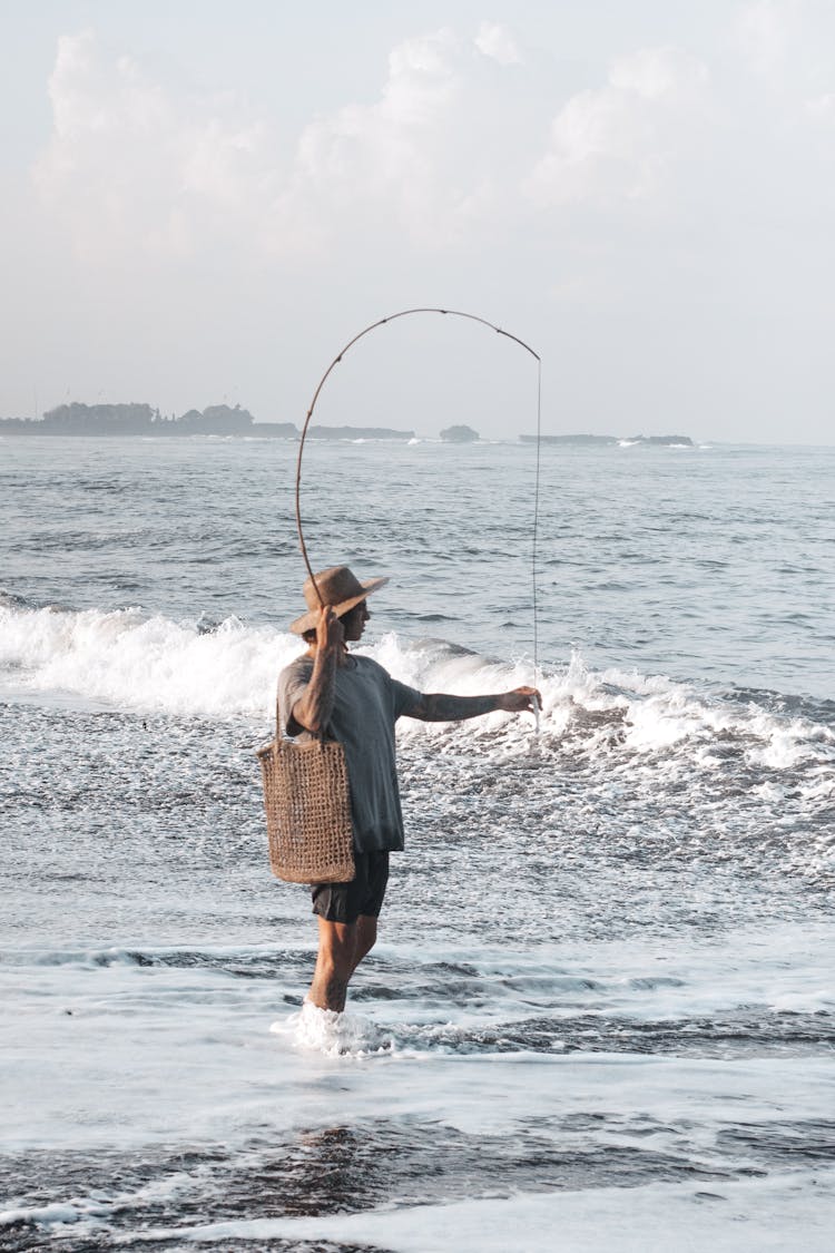 Lone Woman Fishing On A Beach