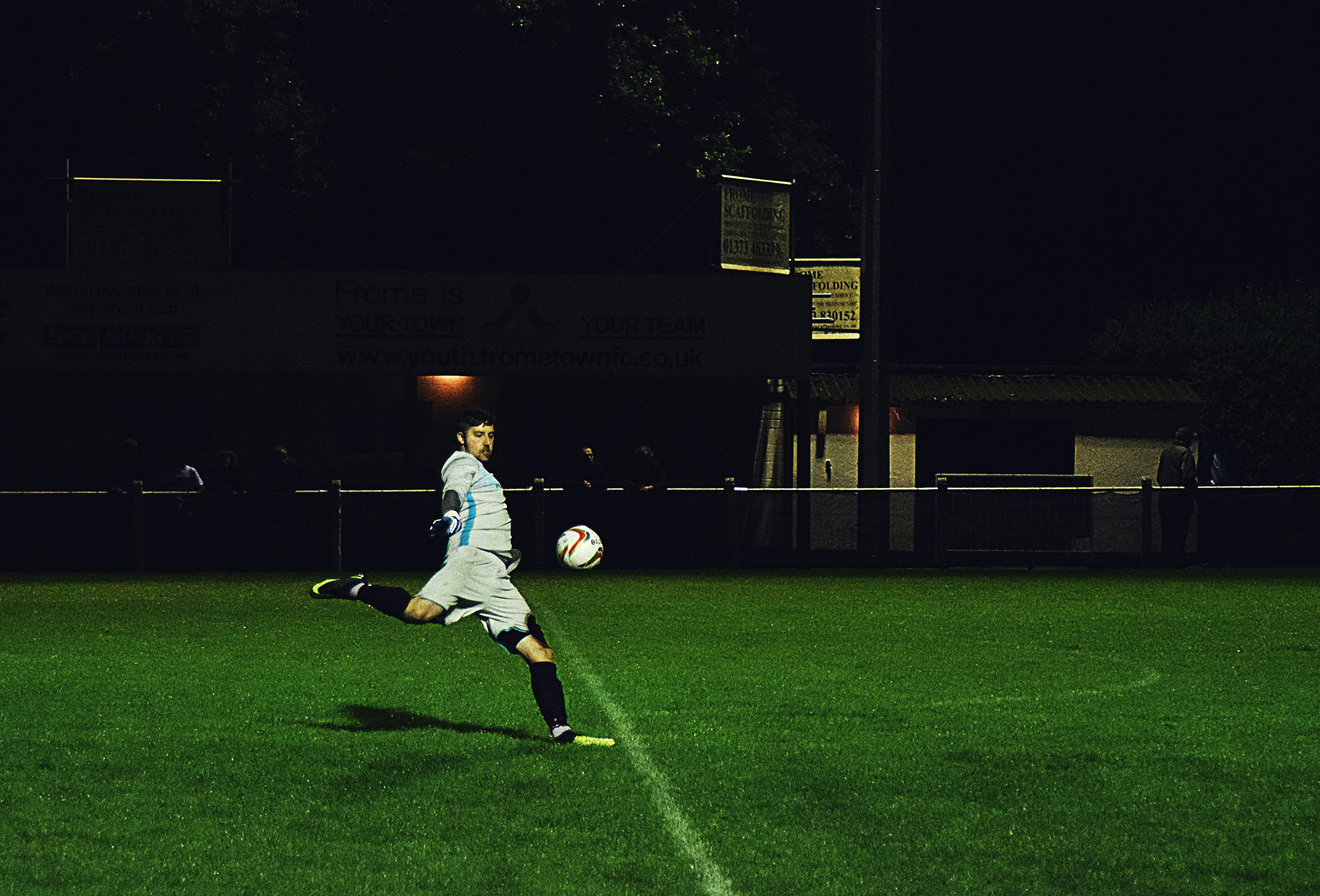 Person Kicks Soccer Ball in Field