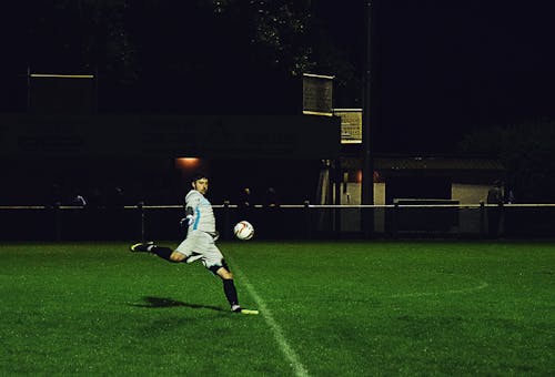 無料 人はフィールドでサッカーボールを蹴る 写真素材