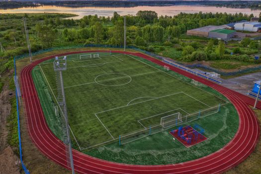 Aerial view of a vibrant sports complex including a football field and surrounding track.
