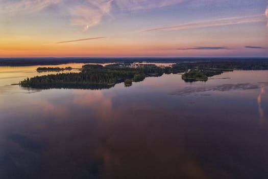 A tranquil aerial view of a lake and forest landscape at sunset in Valday, Russia.