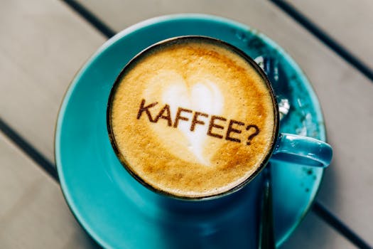 Heart-shaped latte art on cappuccino with a playful 'KAFFEE?' text in Osnabrück.