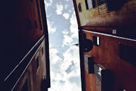 西班牙赫罗纳晴朗天空下，低角度拍摄的小巷建筑景观