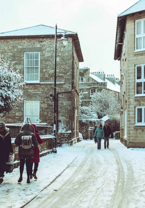 People Walking on Snow Covered Street