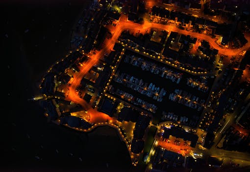 Stunning aerial night view capturing the glowing marina lights and boats docked in England.