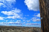 广阔的沙漠景观中，清澈的蓝天上飘着几朵云，凸显了大自然的美丽