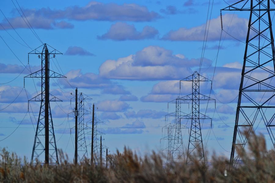 High-voltage transmission towers stretching across open country — photo by Brett Sayles on Pexels