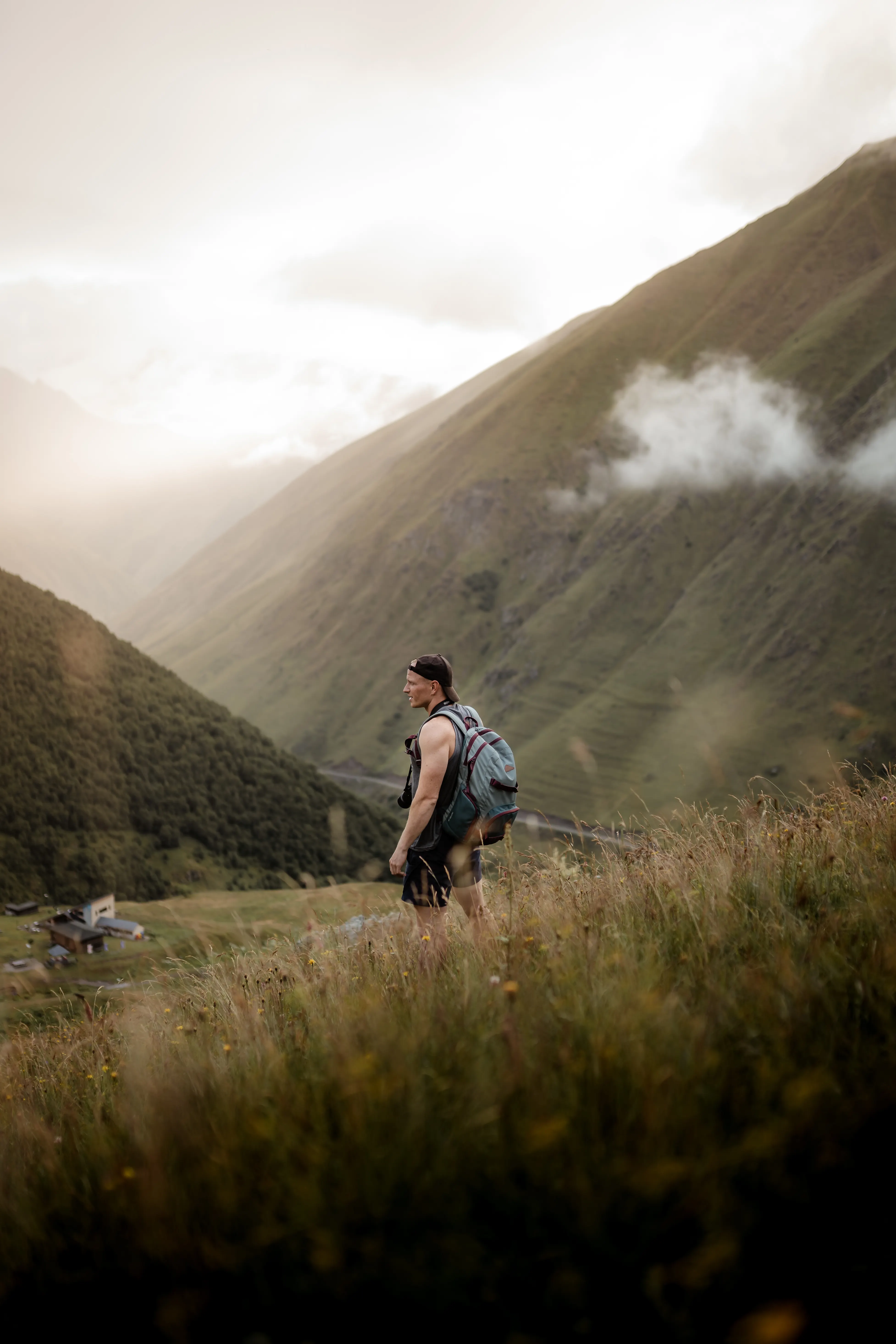 A solo hiker with a backpack walking through misty mountains
