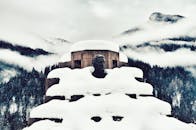 山上雾蒙蒙的，一座白雪皑皑的雕塑矗立其间，四周环绕着霜冻的树木，令人想起冬日的寒意