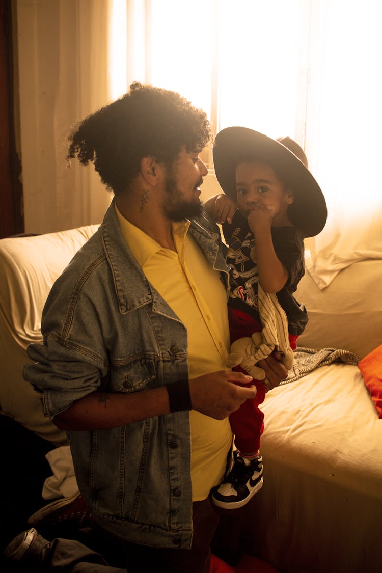 Father Holding Child In Arms At Home