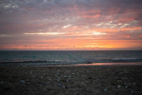 Free Beautiful sunset at the beach with an orange sky and gentle waves in Alakhadzi. Stock Photo