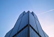 一张低角度拍摄的芝加哥现代摩天大楼照片，天空晴朗，云迹可见