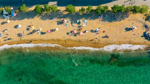 Free Aerial shot of a sunny beach with people enjoying the sand and sea. Stock Photo
