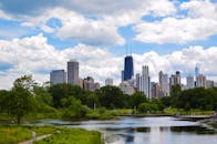 从林肯公园俯瞰芝加哥，绿树成荫，天空蔚蓝，湖泊与天际线尽收眼底