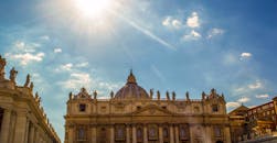 在明媚的阳光下，梵蒂冈城的圣彼得大教堂呈现出壮丽的景色