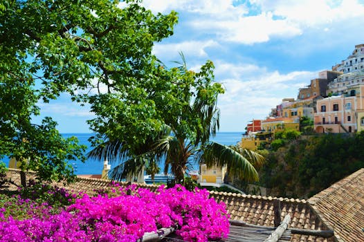 Colorful coastal village with lush flora and sea view, ideal for travel and architecture enthusiasts.