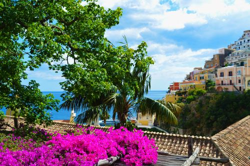 Free Colorful coastal village with lush flora and sea view, ideal for travel and architecture enthusiasts. Stock Photo
