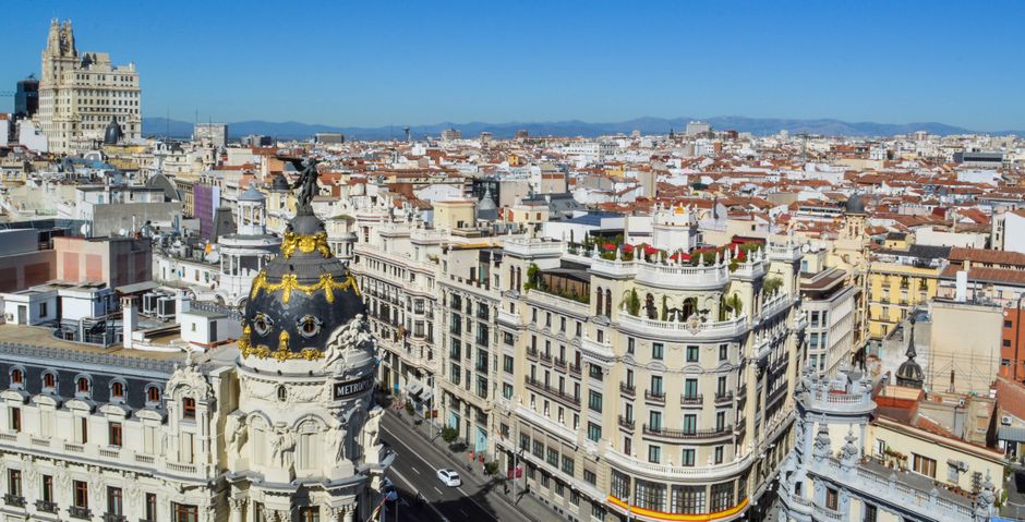 Impresionante vista aérea de la Gran Vía de Madrid que muestra la arquitectura histórica bajo cielos azules claros.
