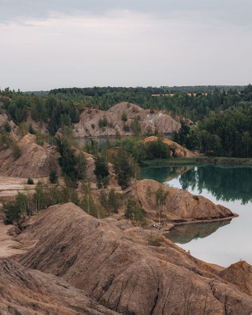 Free Peaceful lake surrounded by rugged hills and lush greenery, perfect for nature photography. Stock Photo