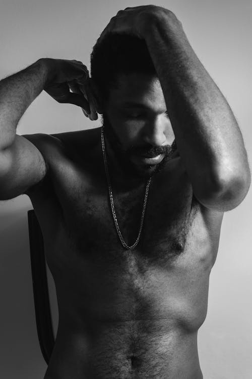 Monochrome Photo of a Shirtless Man Wearing a Necklace