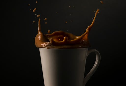Captivating shot of coffee splash in a white cup against a dark background, emphasizing motion and texture.