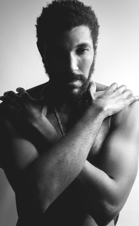 Free Black and White Photo of a Shirtless Man Posing with His Hands on His Shoulders Stock Photo